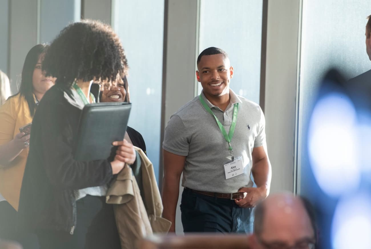 Student walking and smiling at conference